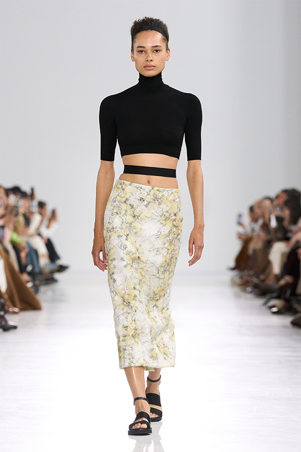 Max Mara Spring/Summer 2026 Fashion Show - Look with Black Cropped Turtleneck and Skirt with Floral Motifs.